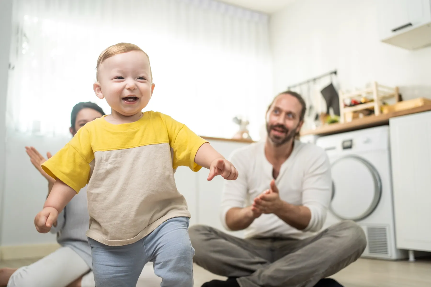 Un bébé souriant fait ses premiers pas vers son papa