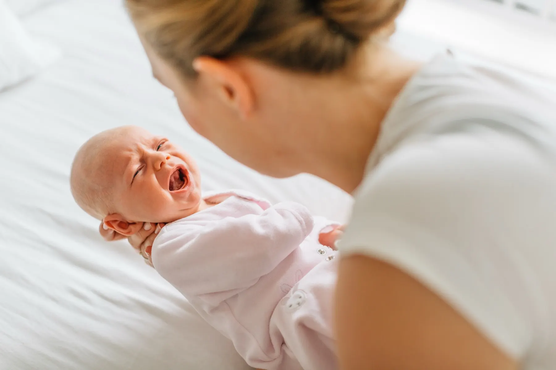 Une maman réconforte son nourrisson qui pleure